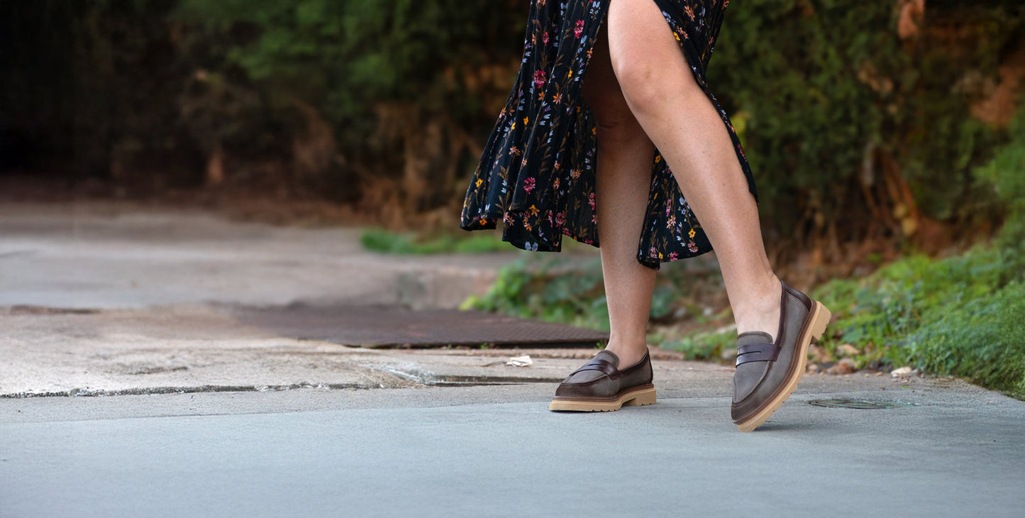 Close up of black and brown shoes standing on hay.