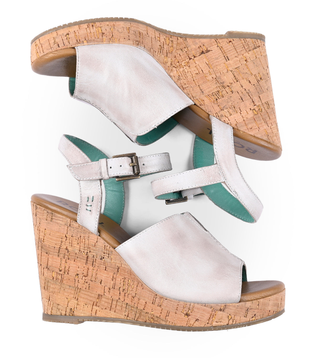 
                  
                    A pair of Roan Deduction women's silver wedge heels with cork bases and green insoles, viewed from above.
                  
                