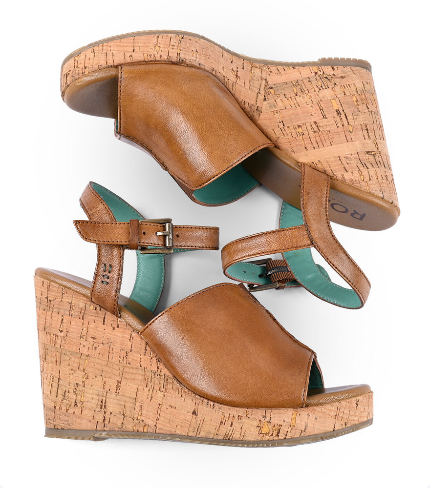 
                  
                    A pair of Roan Deduction full-grain leather wedge sandals with cork heels and adjustable straps, viewed from above on a white background.
                  
                