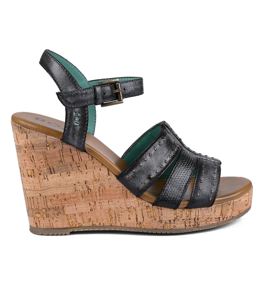 A Roan cork platform wedge heel sandal with a dark green full-grain leather strap adorned with small studs and a buckle closure on a white background.