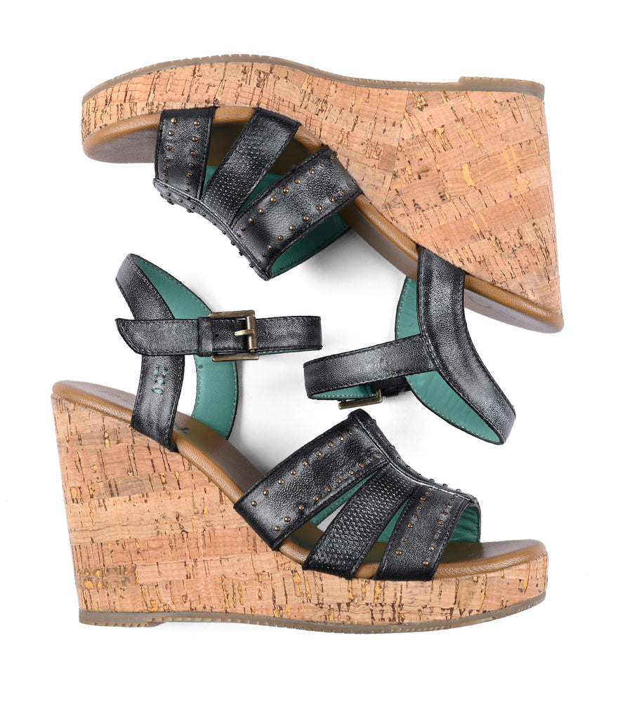 
                  
                    A pair of black and teal platform wedge sandals with cork heels and studded details, viewed from above Different by Roan.
                  
                