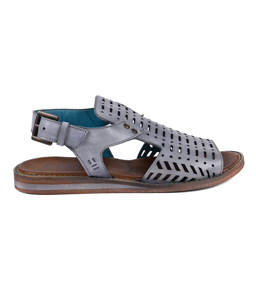 Gray Ballad II gladiator sandal with cut-out designs and a buckle, shown in a side profile against a white background by Roan.