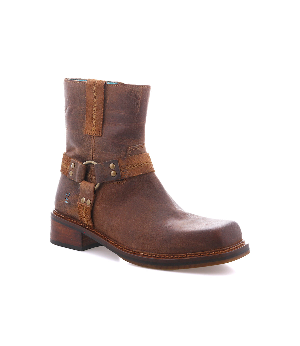 
                  
                    Roan’s Bonsai ankle boot in brown full-grain leather features a low heel and a decorative harness strap, drawing inspiration from classic moto boots, shown on a plain white background.
                  
                