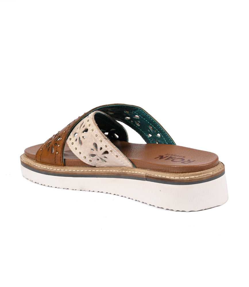 
                  
                    A single brown and teal lightweight Chant sandal with decorative cut-outs and a thick white sole displayed against a white background by Roan.
                  
                