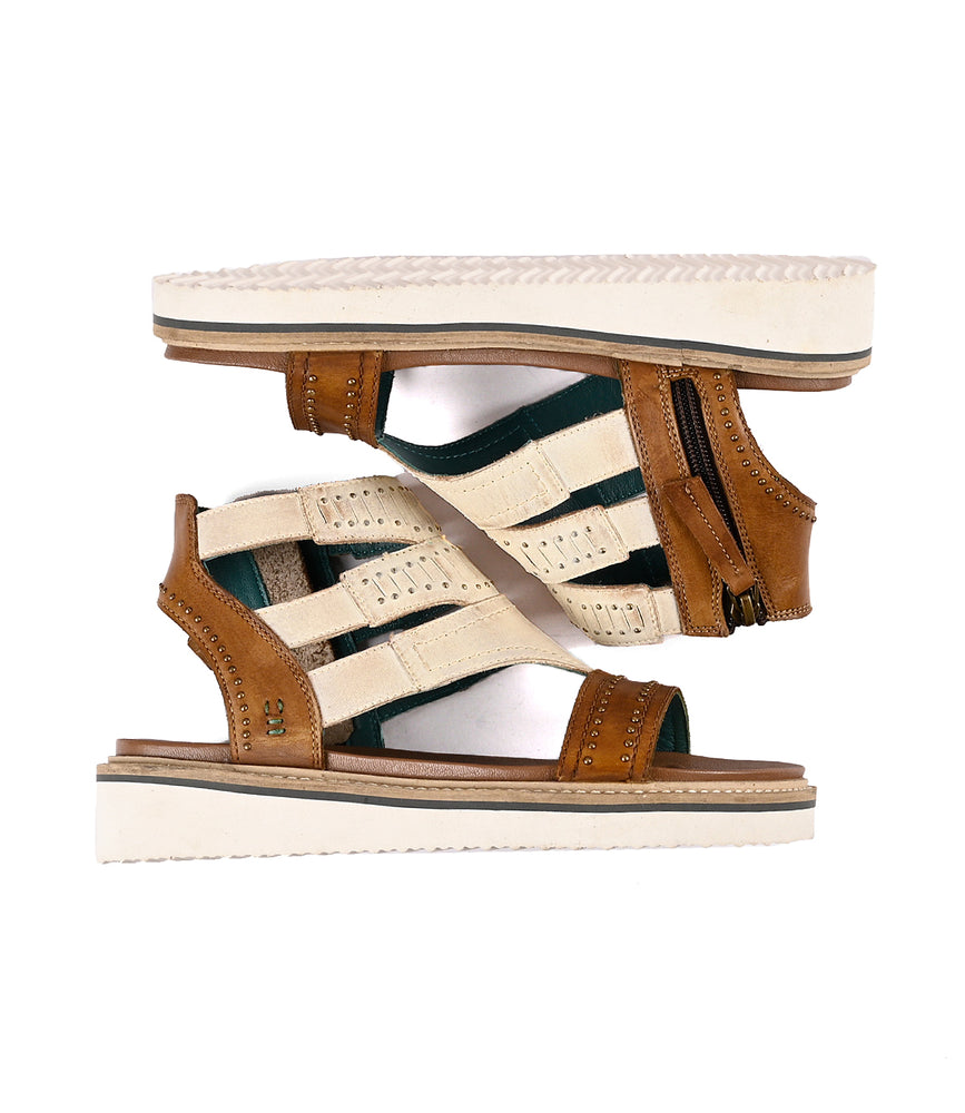 
                  
                    A pair of Carlita II sandals by Roan, made of brown and green full-grain leather, displayed against a white background.
                  
                