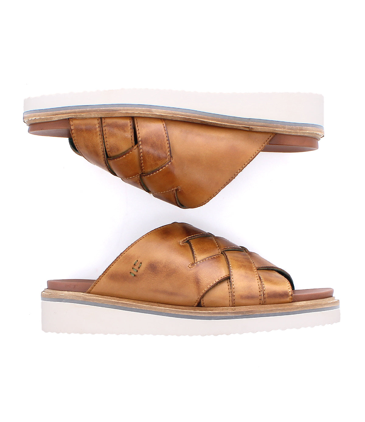 
                  
                    The Roan Cottage is a pair of brown leather slip-on sandals featuring woven detailing, cushioned leather straps, and thick white soles with a flexible foam outsole, shown against a white background.
                  
                