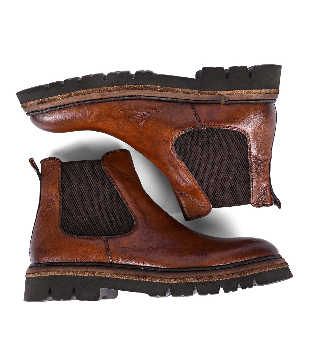 
                  
                    Roan's Defy boots are brown leather Chelsea boots, known for their hand-finishing. They feature black elastic side panels and rugged soles, displayed side by side on a white background.
                  
                