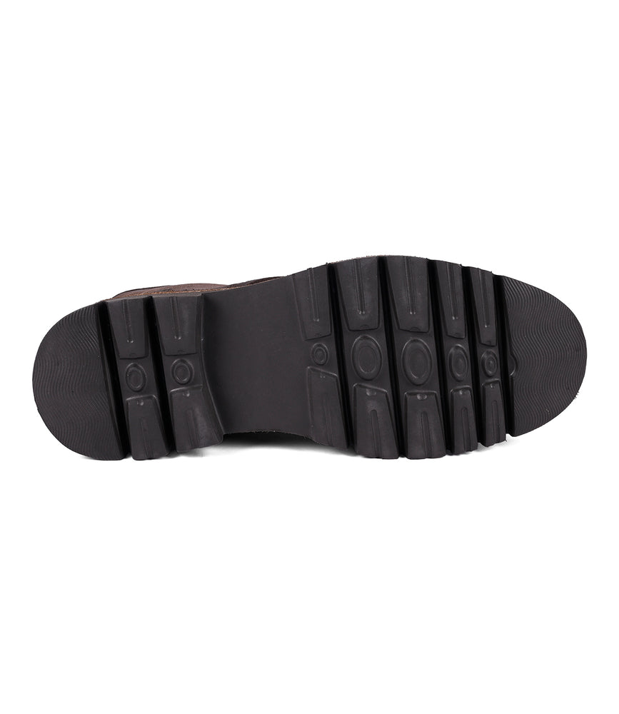 
                  
                    The image displays the black rubber sole of the suede boot called Duty by Roan, showcasing a rugged tread pattern and a flat heel.
                  
                