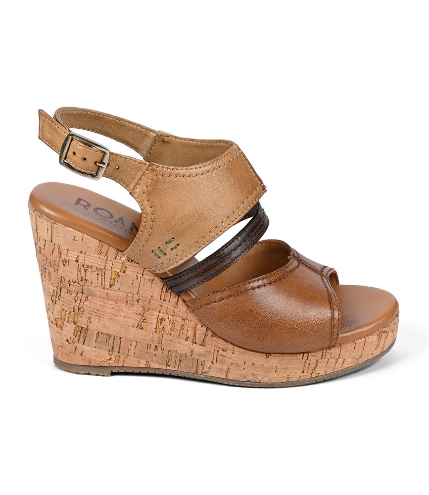 
                  
                    The Roan Decorum sandal features a cork wedge heel, adjustable leather ankle straps, and an open toe design.
                  
                