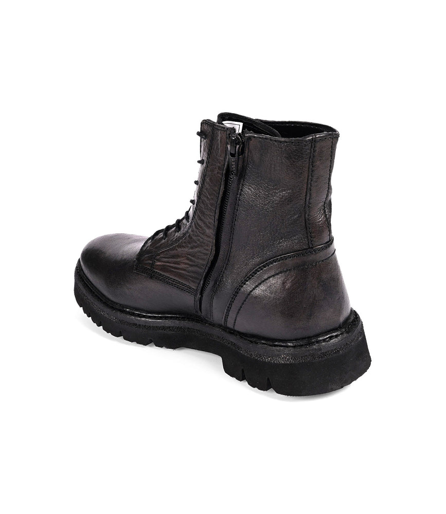 
                  
                    The "Diss" by Roan is a black leather combat-style boot featuring laces, a medial zipper, and a chunky EVA outsole.
                  
                