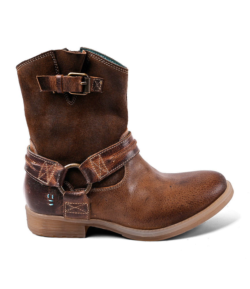 The Roan Flair is a brown leather ankle boot with decorative straps, buckle, ring detail on the side, and subtle Western stitching, shown on a white background.