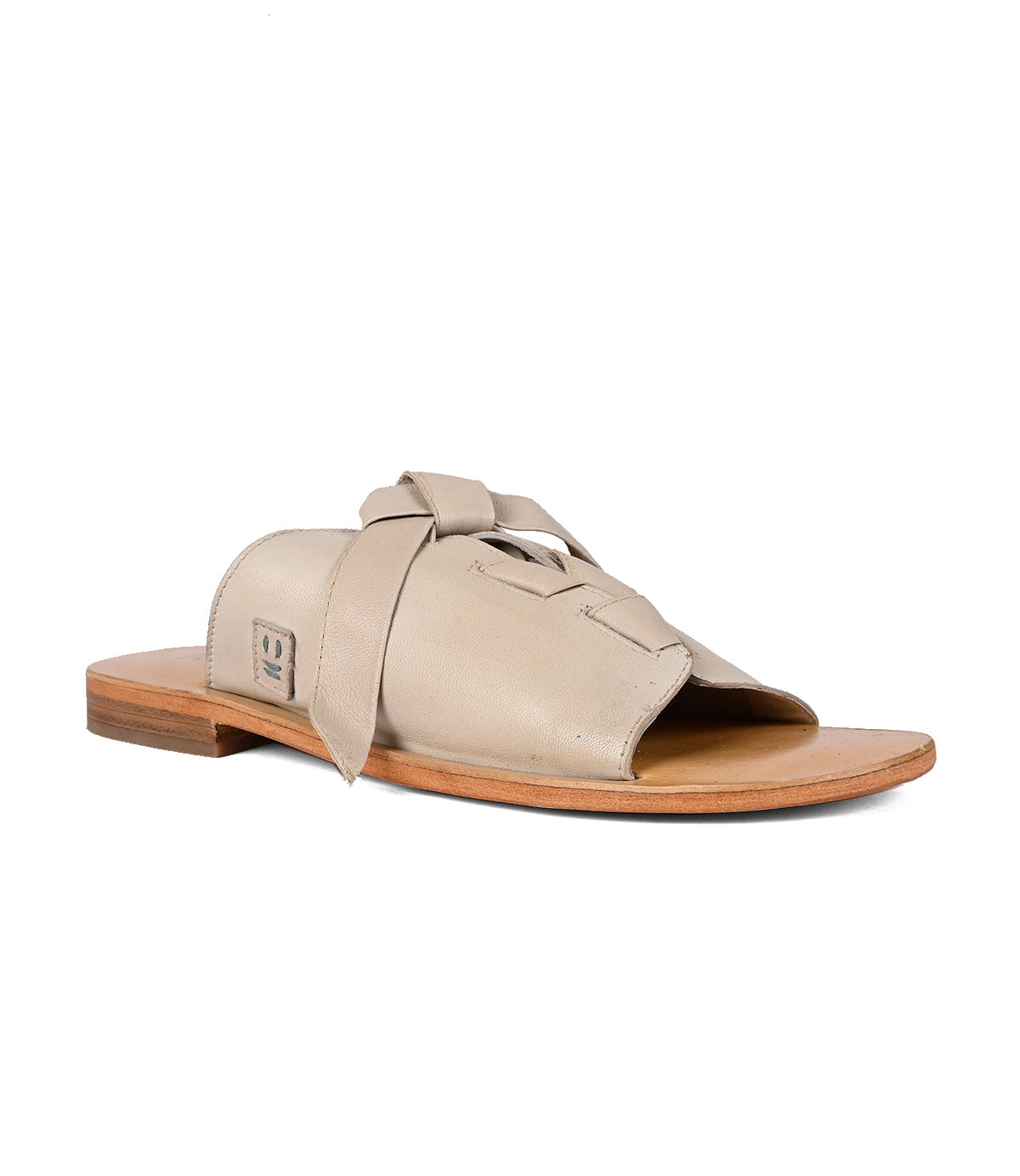 
                  
                    Beige Roan women's Grapevine slide sandal with a bow detail and adjustable leather straps on a white background.
                  
                