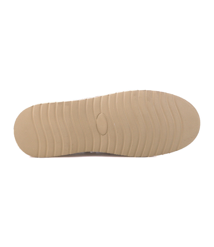 
                  
                    The Roan Glory suede boat shoe features a tan rubber sole with horizontal grooves and an oval-shaped center indentation, shown here from the bottom view.
                  
                