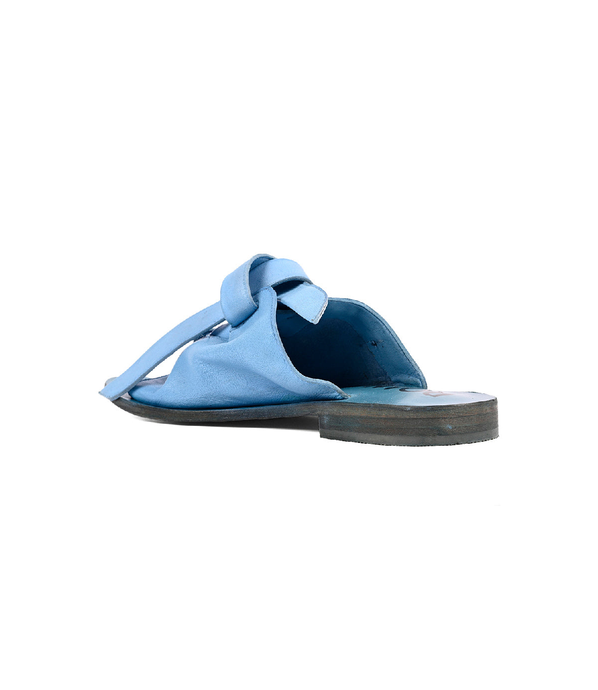 
                  
                    The Roan Grapevine is a single blue slip-on sandal with a bow detail and leather outsole, shown from the back at an angle against a white background.
                  
                