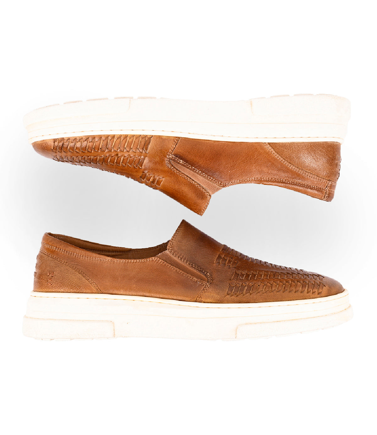 
                  
                    The Roan Gregor features brown handwoven goat leather slip-on shoes with woven detailing and thick white rubber soles, displayed side by side on a white background.
                  
                
