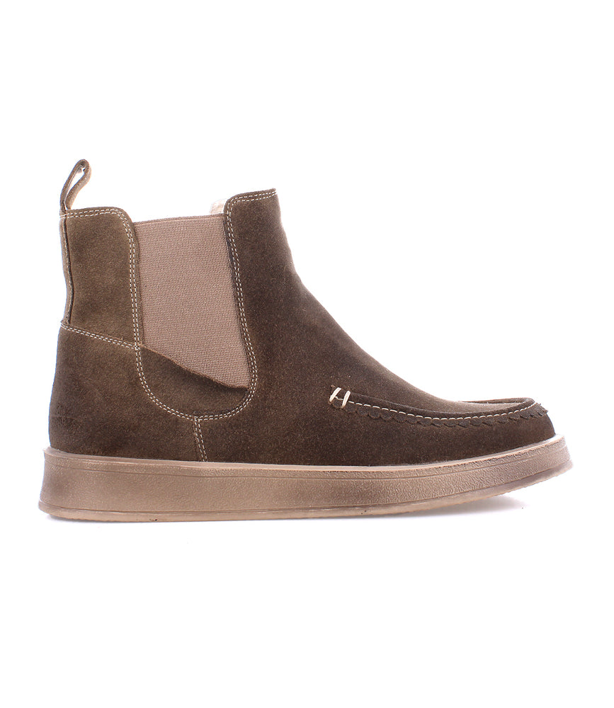 The Roan Heap is a brown slip-on boot with a suede upper, elastic side panels, heel pull tab, and a flat rubber sole—perfect for casual wear. Shown in left side profile view.