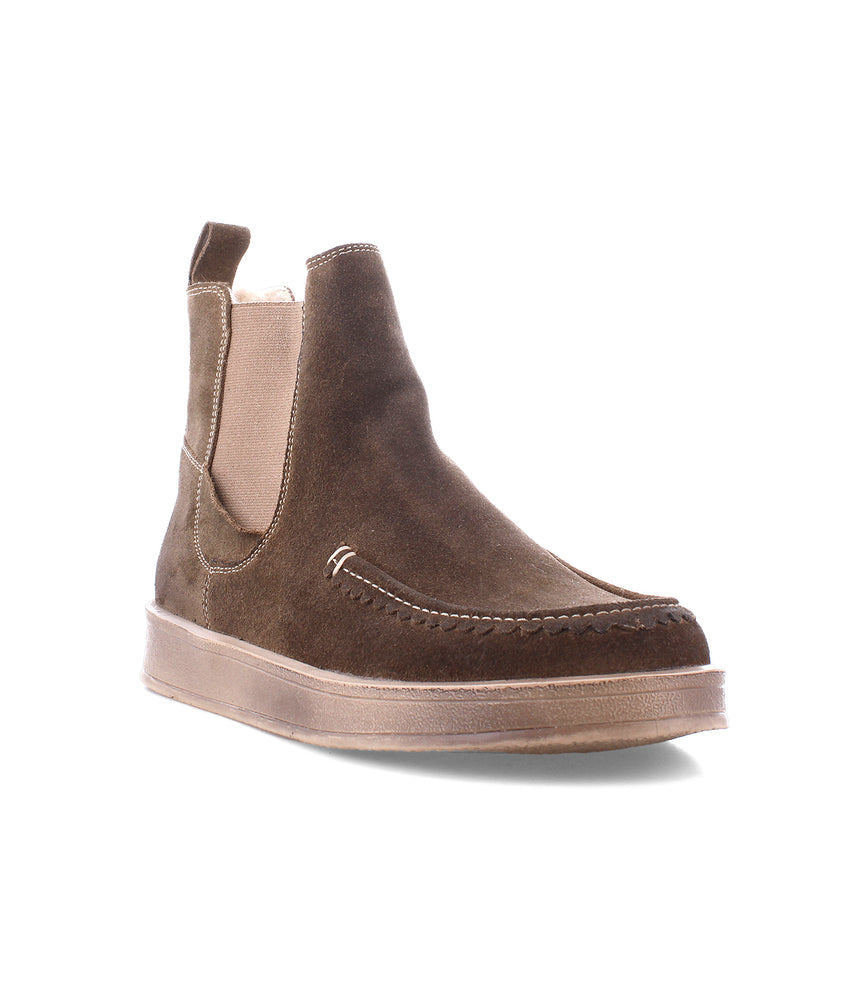 
                  
                    The Roan Heap is a brown suede slip-on with a moc toe, elastic side panels, and a flat rubber sole for casual wear, shown on a white background.
                  
                