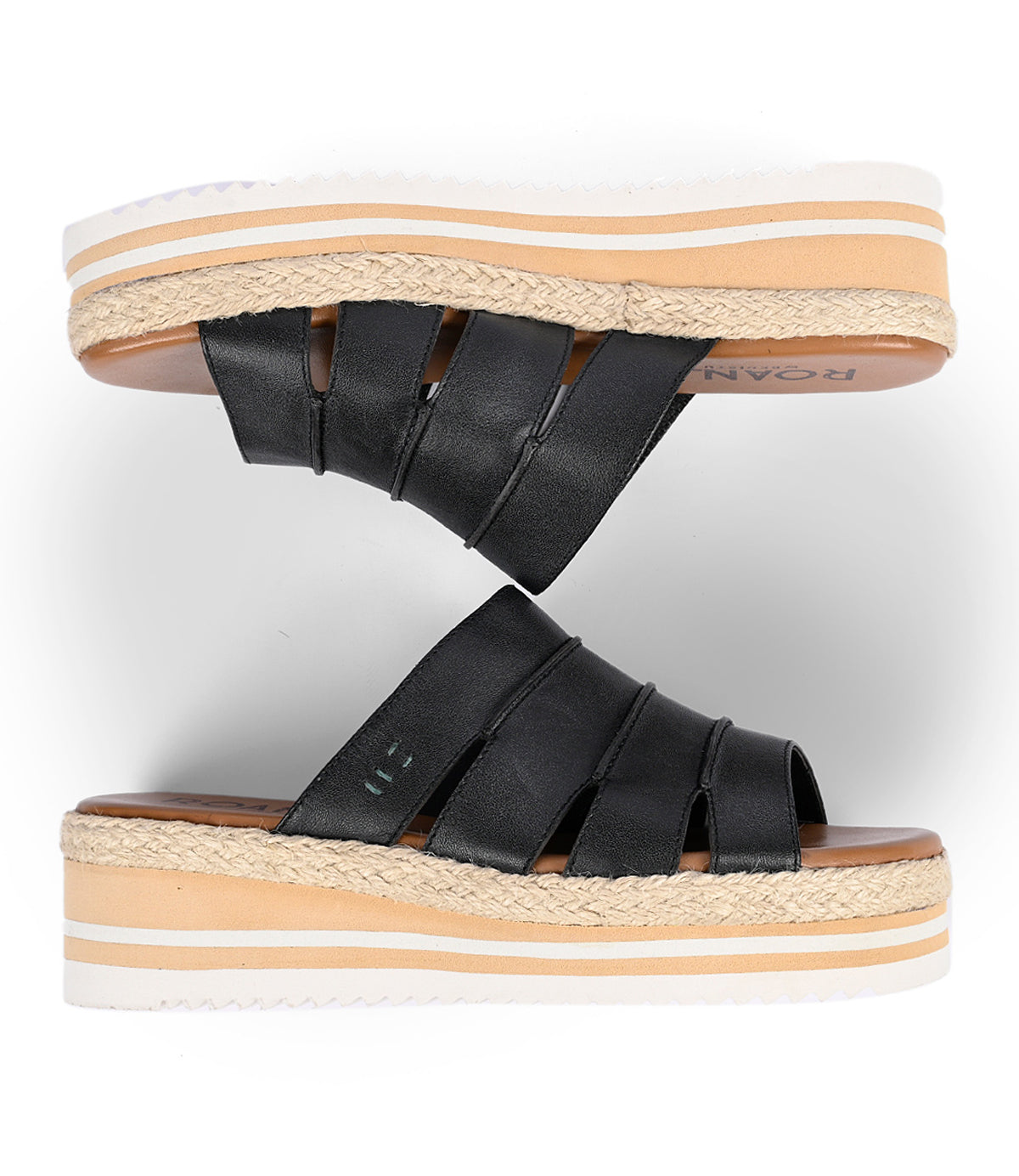 
                  
                    The Roan "Incant" sandals have black straps, a cork-like midsole, and a thick white sole. With a cushioned footbed for comfort, they embody boho-chic style. Displayed on a white background in two positions to highlight their design.
                  
                