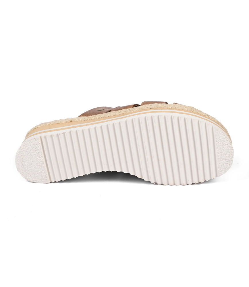 
                  
                    The Incant platform slide sandal by Roan features a boho-chic sole with a textured, ribbed pattern in a white and tan design.
                  
                