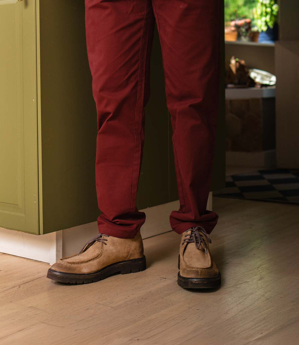 Roan Kickoff tan suede moc-toe chukka boots with lug soles worn with maroon trousers.