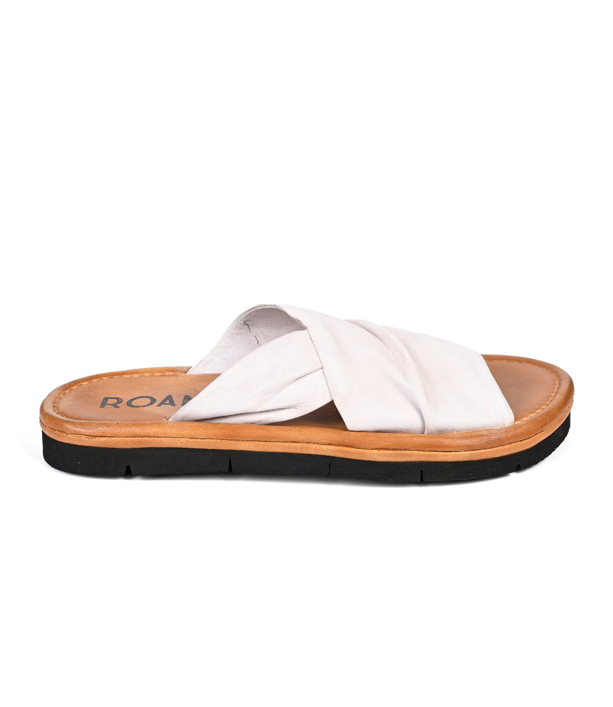 The Nosy sandal by Roan features leather crisscross straps in white, a tan sole, and a black outsole—perfect for an effortless summer style, viewed from the side.