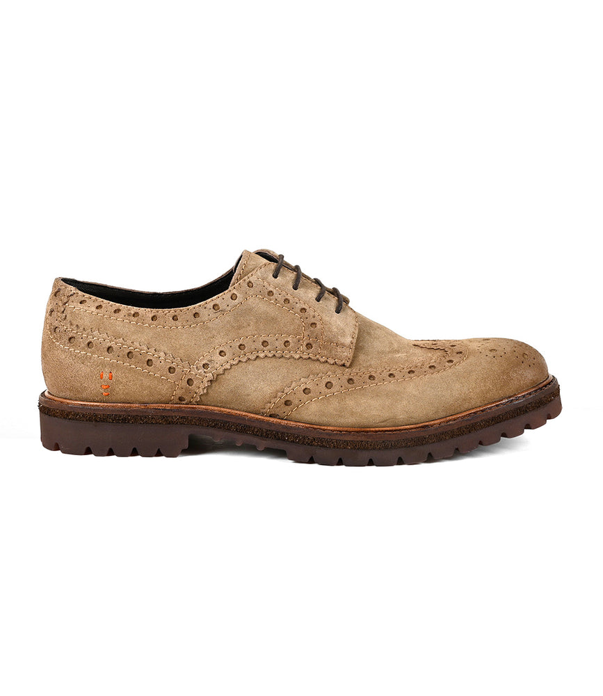 Roan Phiz men’s dress shoe in tan suede features wingtip brogue detailing, decorative perforations, lace-up closure, and a dark brown chunky lug sole, shown in side profile.