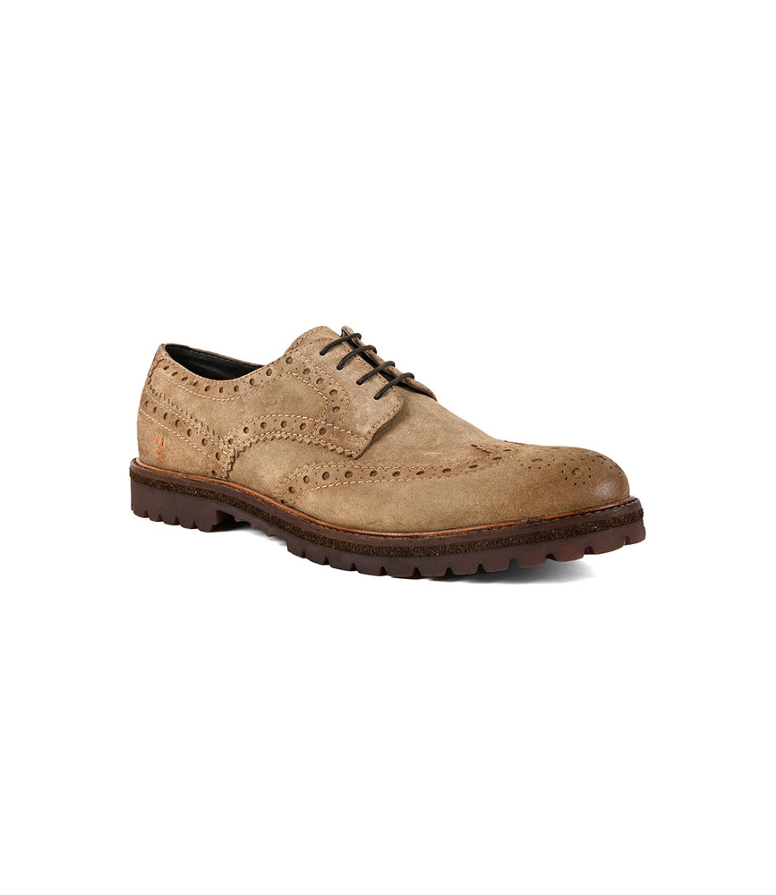 The Roan Phiz is a tan suede wingtip brogue derby shoe with a chunky lug sole, dark brown exterior, and black interior lining, shown on a white background.