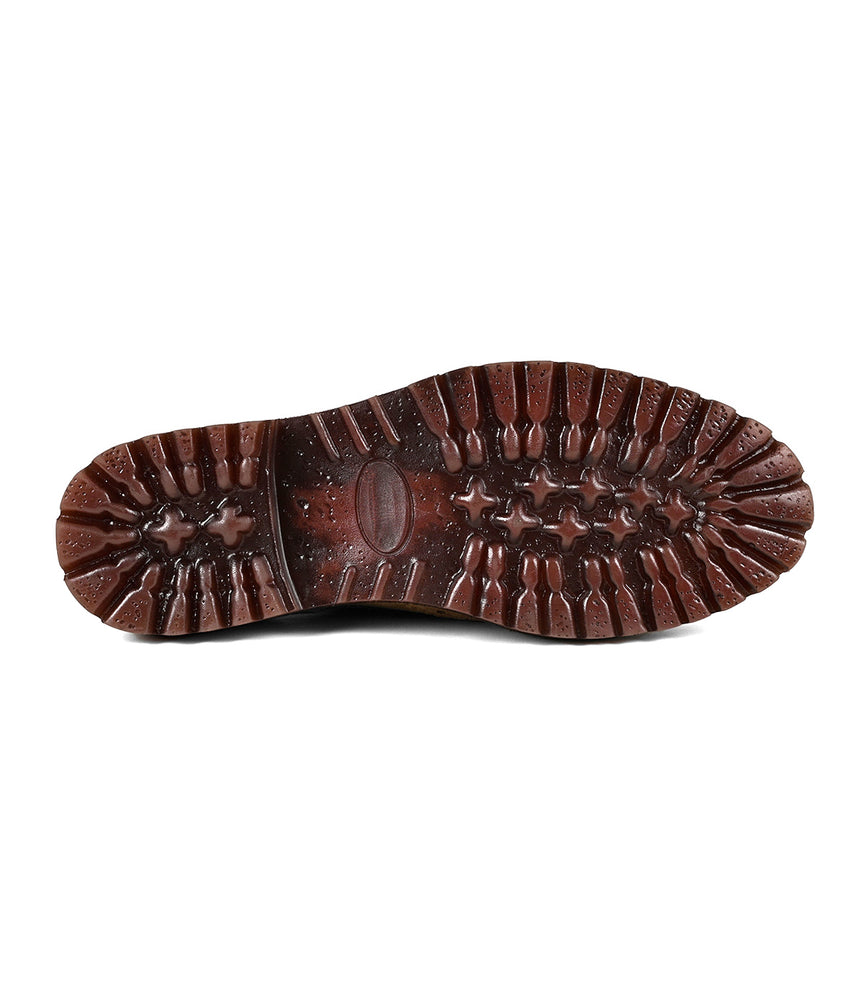 
                  
                    A close-up of the brown, textured chunky lug sole on the Roan Phiz boot shows deep treads for traction and durability reminiscent of men's dress shoes.
                  
                