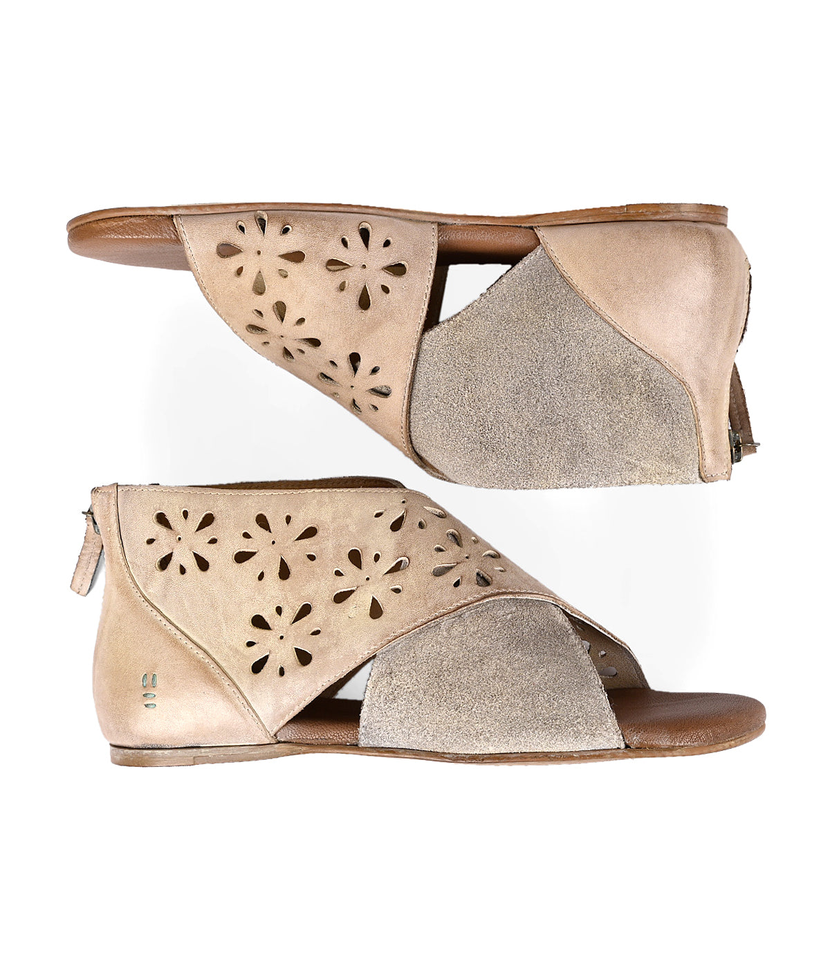 
                  
                    A pair of Roan Rotation suede women's sandals with decorative laser-cut designs, featuring a zipper at the heel and a small wedge heel, displayed against a white background.
                  
                