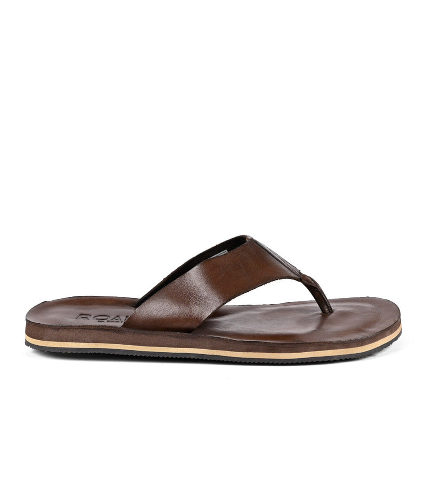 
                  
                    A brown distressed leather flip-flop sandal with a Roan branded insole on a white background.
                  
                