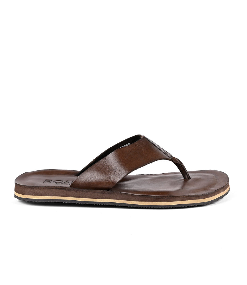 A brown distressed leather flip-flop sandal with a Roan branded insole on a white background.