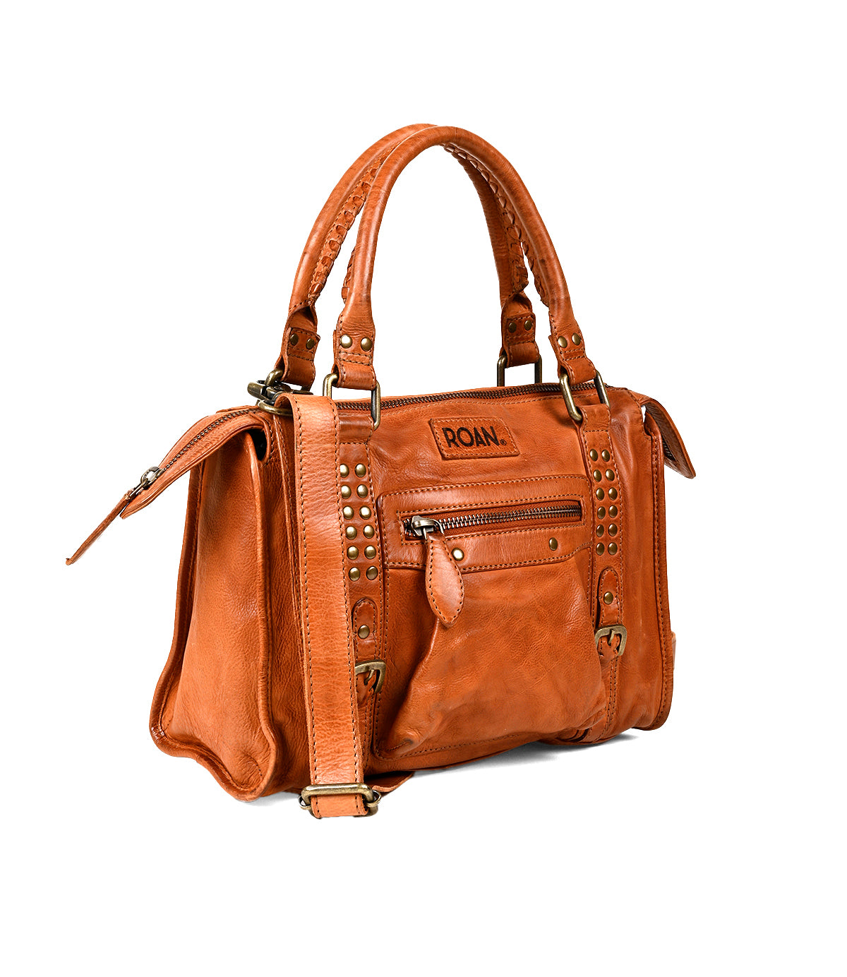 
                  
                    The Roan Visual is a brown leather satchel with double handles, gold studded accents, a front zip pocket, and a detachable shoulder strap.
                  
                