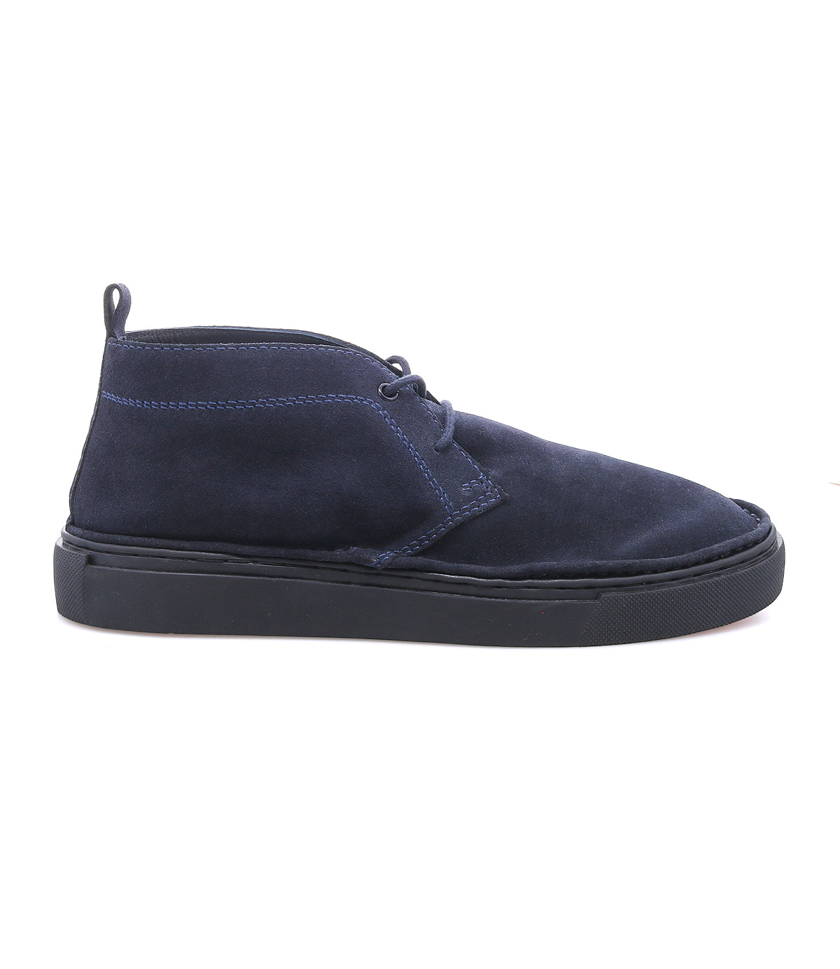 
                  
                    The Roan Volunteer is a navy blue suede chukka boot with black laces, a sneaker-style sole, and a pull tab at the heel, shown from the side on a white background.
                  
                