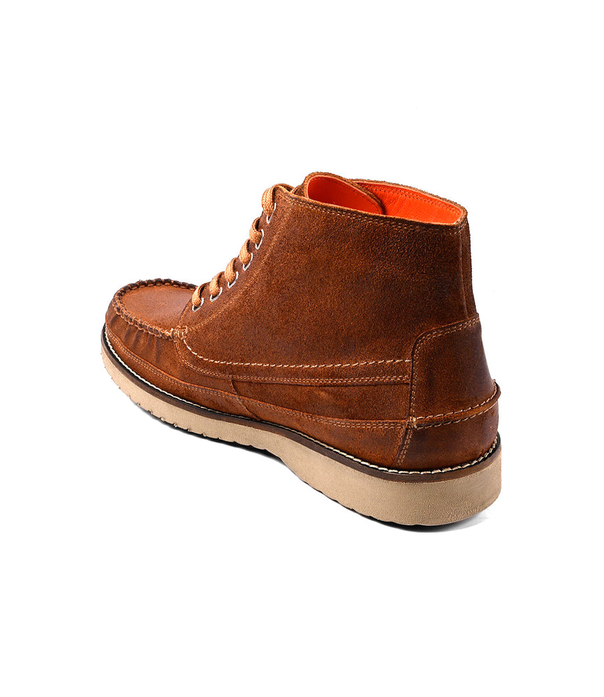 
                  
                    The Roan Warden is a brown leather moc toe chukka boot with a beige rubber sole and cushioned insole, shown from the back and side on a white background.
                  
                