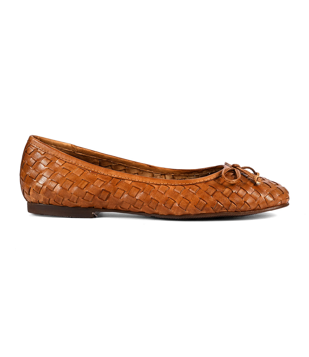 Brown hand-woven leather flat shoe featuring a small bow on the front. These Roan Business slip-on ballerina shoes boast a flat sole and rounded toe, showcasing intentional craftsmanship in every detail.