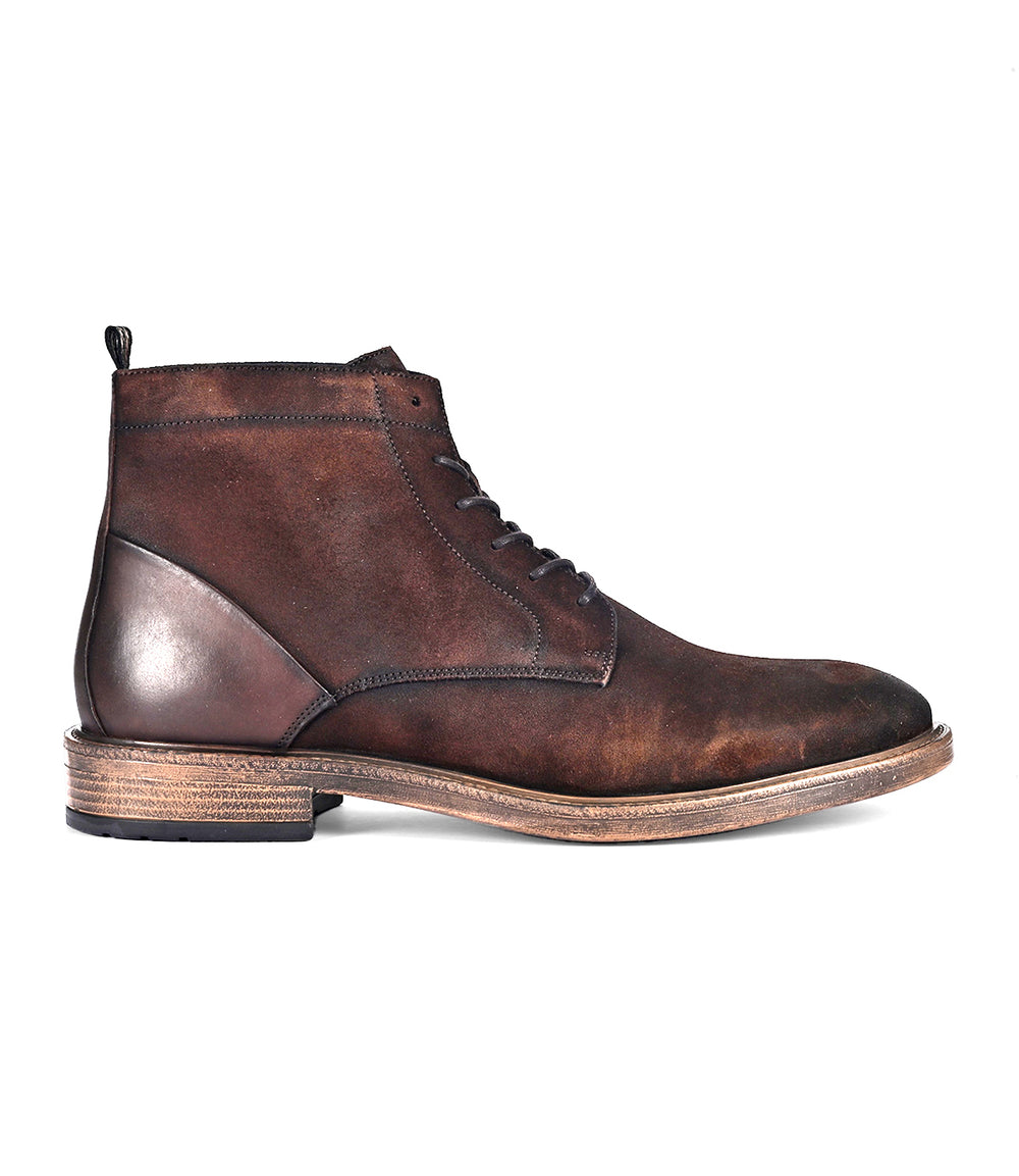 The Joyride by Roan is a brown full-grain leather ankle boot featuring a lace-up closure and a wooden sole.