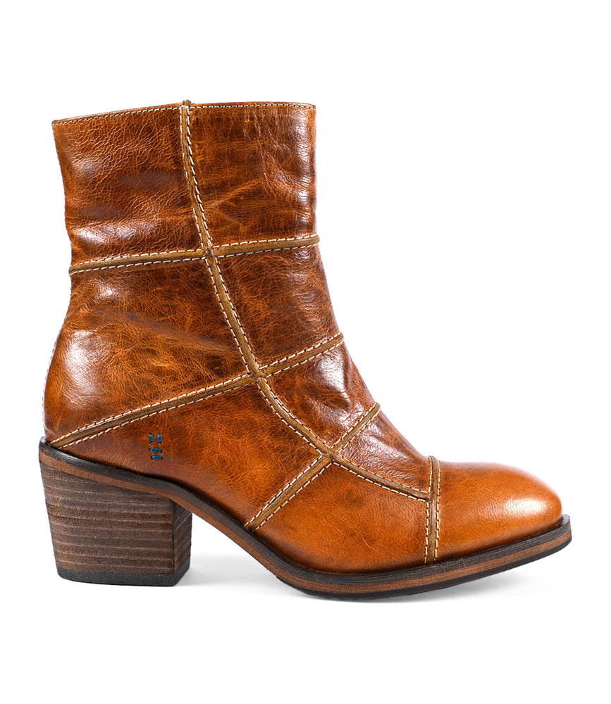 The "Often" by Roan is a brown leather ankle boot featuring intricate piping and stitched panel details. It comes with a block heel and a slightly distressed finish, making it a statement piece that exemplifies creative craftsmanship—perfect for those who appreciate style and flair.