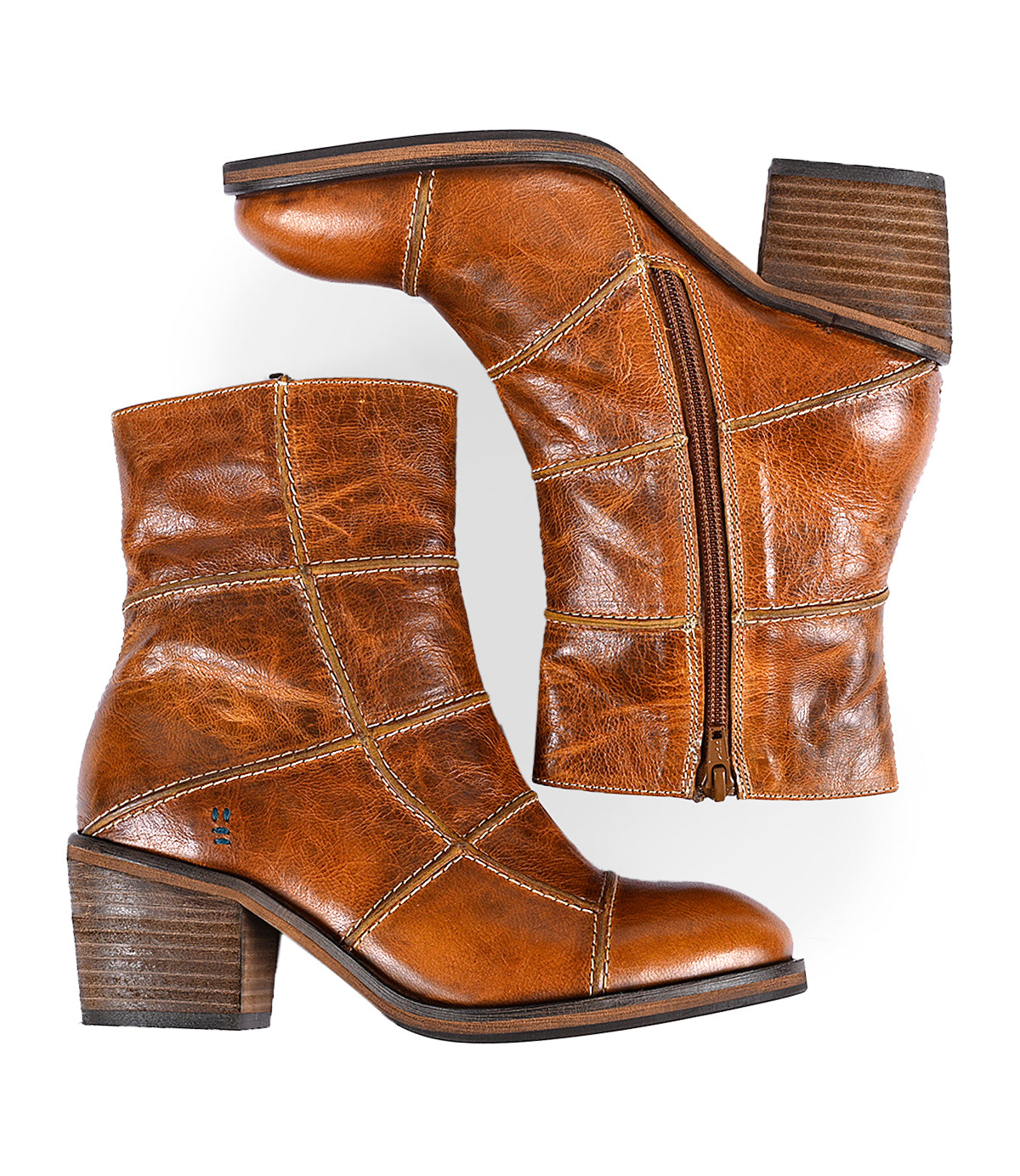 
                  
                    A pair of Roan's Often brown leather ankle boots showcasing intricate piping, complete with chunky heels and side zippers, displayed against a white background.
                  
                